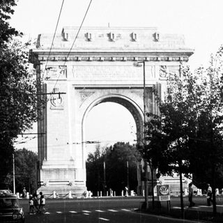 Grand arch monument on city street.