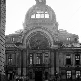 Grand neoclassical building with dome and emblem.
