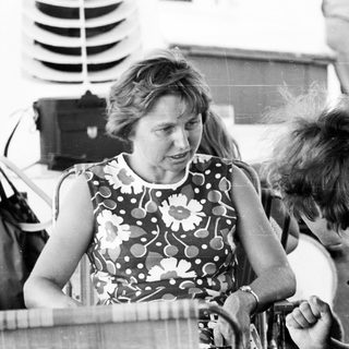 Two people conversing outdoors near a boat.