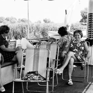 Group of women relaxing outdoors on deck chairs.