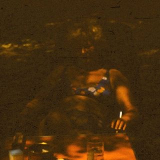 Person preparing food in dimly lit kitchen.