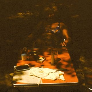 Person preparing food in dimly lit kitchen.