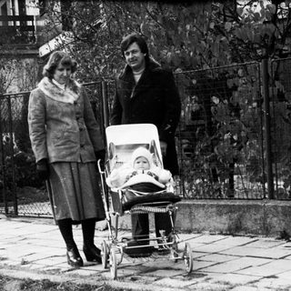 Two women pushing a baby stroller outdoors.