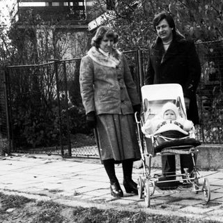 Two women pushing a baby stroller outdoors.