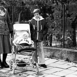 Family with baby stroller outdoors in residential area.
