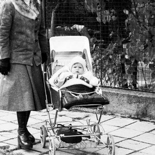 A woman pushing a baby stroller outdoors.