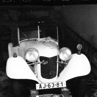 Vintage white car with AJ-63-81 license plate.