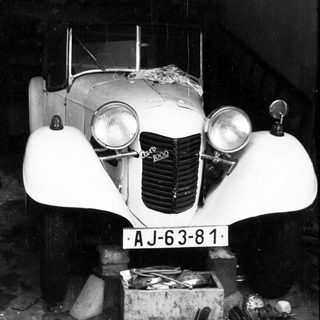 Vintage car labeled "AJ-63-81" in dim lighting.