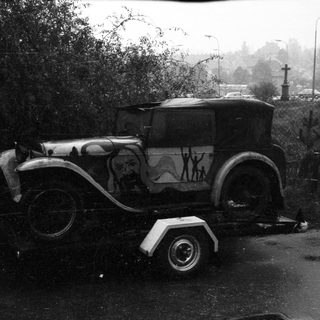 Vintage car on trailer, decorated with silhouettes.
