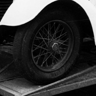 Vintage white convertible car on trailer.