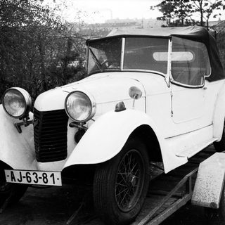 Vintage white convertible car on trailer.