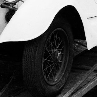 Vintage white convertible car on trailer.