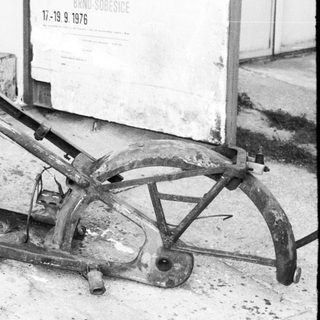 Destroyed motorcycle frame on workshop floor.