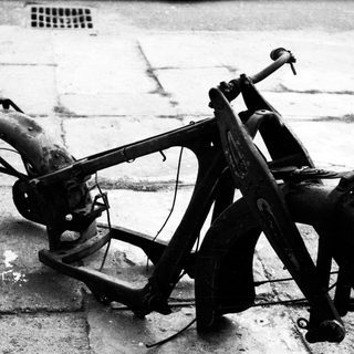 Vintage motorcycle frame, stripped and damaged.