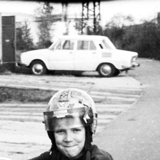 Person riding vintage motorcycle on road.