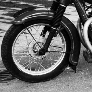 Classic black-and-white motorcycle with sidecar, parked outdoors.
