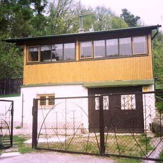 Two-story yellow and white building with gated entrance.