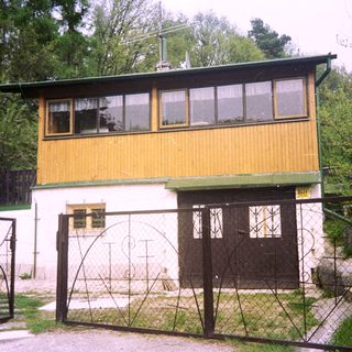 Two-story yellow and white building with gated entrance.