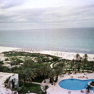 Luxury resort with pool, beach, and ocean view.