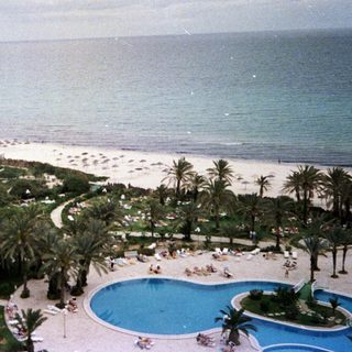 Luxury resort with pool, beach, and ocean view.