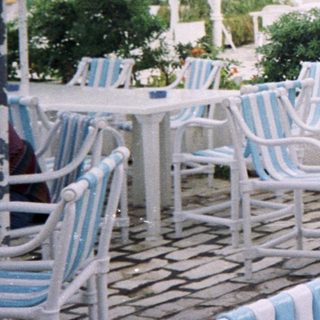 Outdoor café with people seated under striped umbrellas.