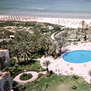Luxury resort with pools, beach, and palm trees.