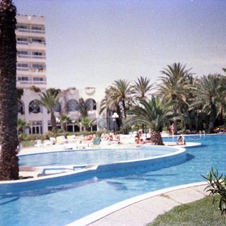 Luxury resort pool area with guests relaxing.