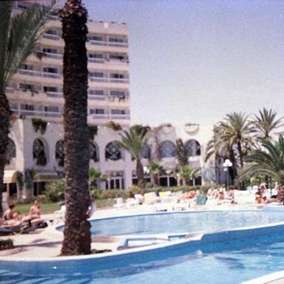 Luxury resort pool area with guests relaxing.