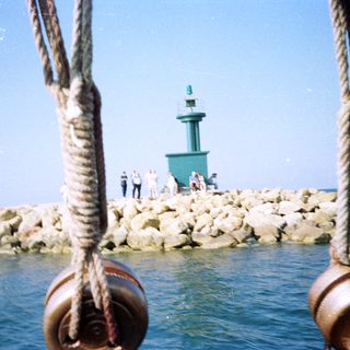 Marina breakwater with lighthouse and people.