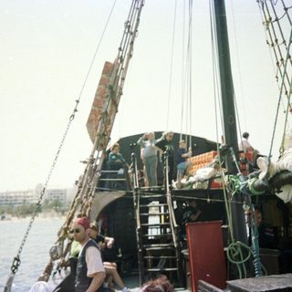Traditional sailing ship with crew and passengers.