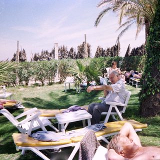 Sunbathing adults at a resort poolside.