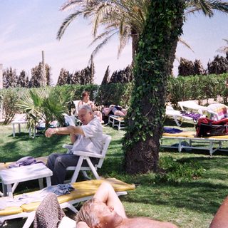 Sunbathing adults at a resort poolside.