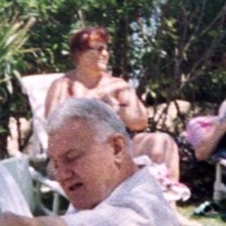 Sunbathing adults at a resort poolside.