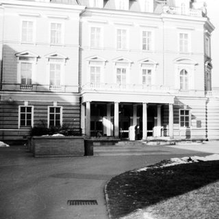 Grand neoclassical building entrance with winter landscape.