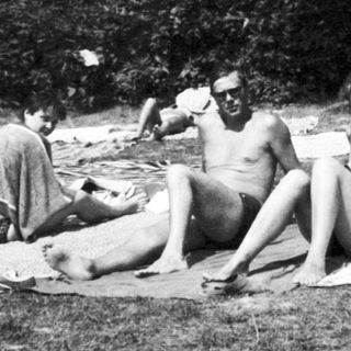 People sunbathing and relaxing outdoors on towels.