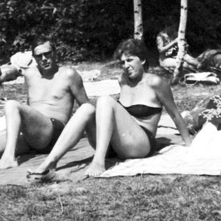 People sunbathing and relaxing outdoors on towels.