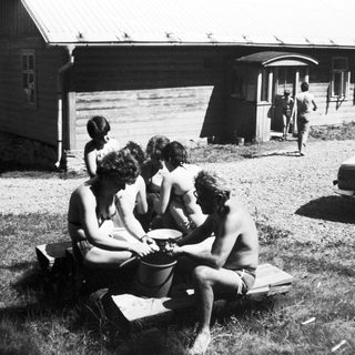 Group of people playing with bucket outdoors.