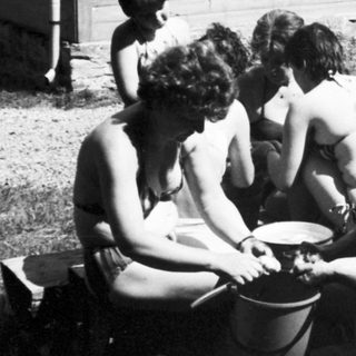 Group of people playing with bucket outdoors.