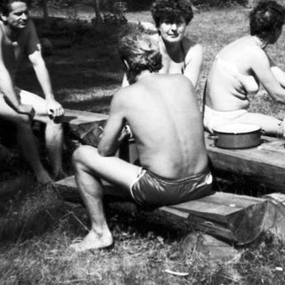Group of people relaxing outdoors by water.