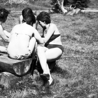 Group of people relaxing outdoors by water.