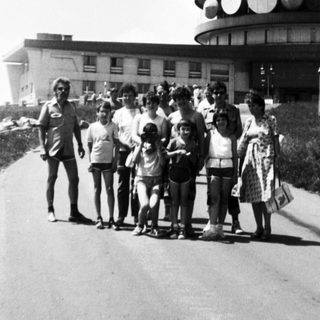 Group posing near tall observation tower.