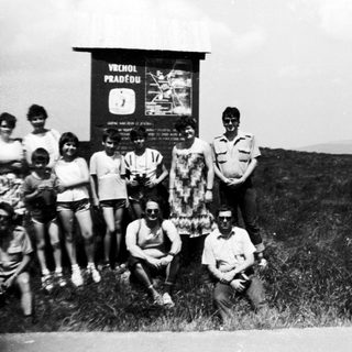 Group posing near "Vercors Pradélo" sign in mountainous area.