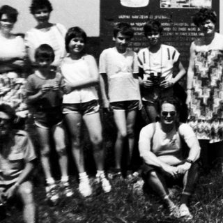 Group posing near "Vercors Pradélo" sign in mountainous area.