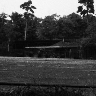 Rural area with small house and open field.