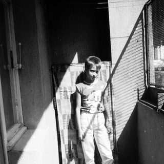 Young boy holding tennis racket in indoor hallway.