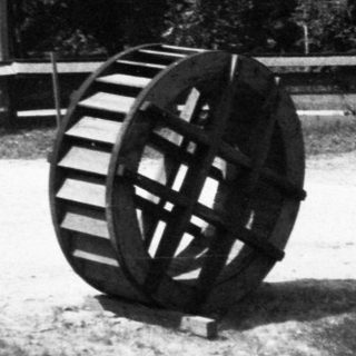 Large water wheel beside historic water channel.