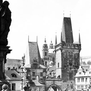 Historic Prague Charles Bridge with statues and pedestrians.