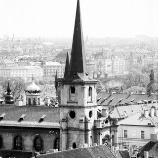Historic church spire overlooking European cityscape.