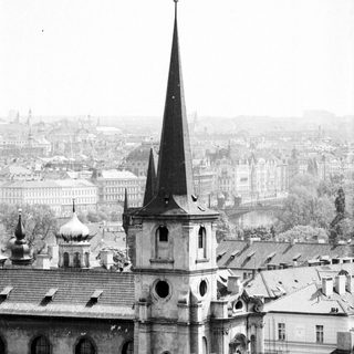 Historic church spire overlooking European cityscape.