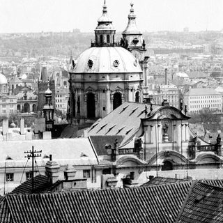 Baroque church dome over historic city rooftops.
